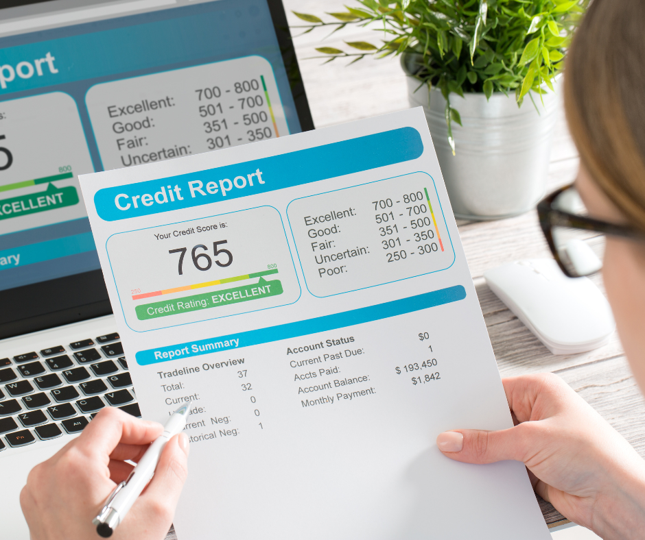 Person reviewing a credit report showing a 765 excellent credit score on a laptop during a spring credit checkup to monitor financial health